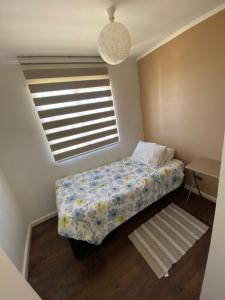 a small bedroom with a bed and a window at Tronador I in Puerto Montt +3 photos