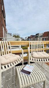 two white chairs on a balcony with a book at Stationbeds Studio-2 Alkmaar in Alkmaar