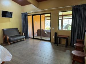 a room with a bed and a chair and a window at Rainbow Valley Lodge Costa Rica in Monteverde Costa Rica