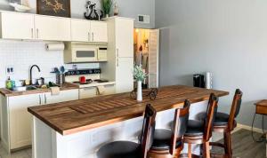 a kitchen with a wooden counter with chairs around it at Southwood Serenity in Lake Ozark