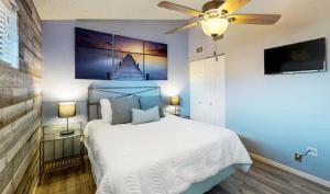 a bedroom with a white bed and a ceiling fan at Southwood Serenity in Lake Ozark