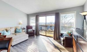 a living room with a couch and a large window at Southwood Serenity in Lake Ozark