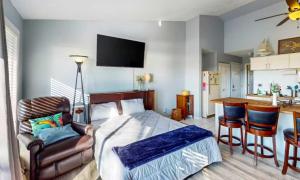 a bedroom with a bed and a table and a kitchen at Southwood Serenity in Lake Ozark