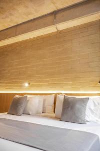 a bed with white pillows in a room at beminimal jardines in Medellín
