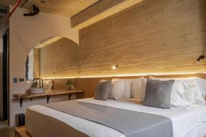 a bedroom with a large bed with a brick wall at beminimal jardines in Medellín