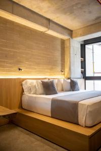 a large bed sitting on a wooden bench in a room at beminimal jardines in Medellín