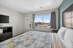 a bedroom with a large bed and a window at Super 7 inn in Joplin +5 photos