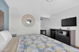 a bedroom with a bed and a flat screen tv at Super 7 inn in Joplin