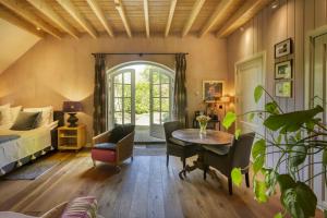 a bedroom with a bed and a table and chairs at Bedandbreakfast De Vallei in Heelsum
