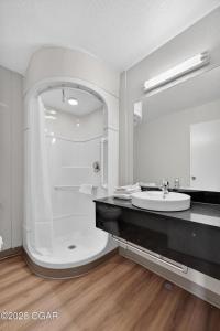 a white bathroom with a sink and a mirror at Super 7 inn in Joplin