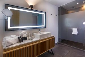 a bathroom with a sink and a mirror and a shower at Hotel Luure Bosque Real in Mexico City