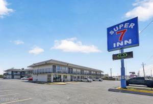a super inn sign in front of a parking lot at Super 7 inn in Joplin
