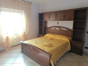 a bedroom with a large wooden bed and a window at Sara's Home Vetralla in Vetralla