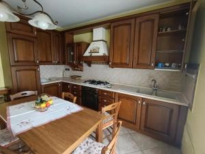 a kitchen with wooden cabinets and a wooden table at Sara's Home Vetralla in Vetralla