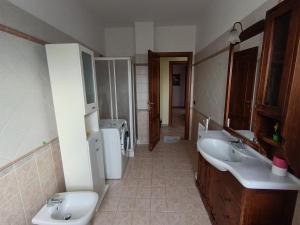 a bathroom with two sinks and a toilet at Sara's Home Vetralla in Vetralla +15 photos