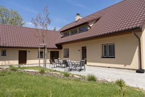 a house with a table and chairs in the courtyard at Penzion Rališka in Horní Bečva