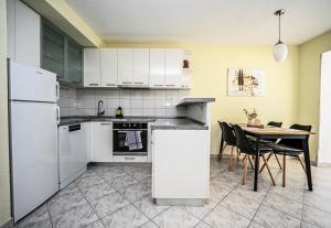 a kitchen with white appliances and a table with chairs at Mikuljan Apartments- Free Parking -5 Min by Walk to Beach in Stobreč