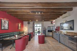 a restaurant with red walls and a bar with red stools at Logis Auberge De Launay in Limeray