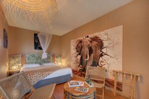 a bedroom with an elephant painting on the wall at Logis Auberge De Launay in Limeray +127 photos