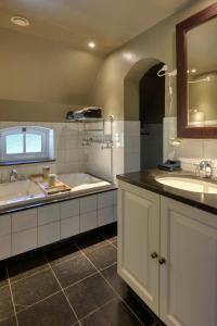 a bathroom with two sinks and a bath tub at Bedandbreakfast De Vallei in Heelsum +43 photos