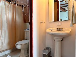 a bathroom with a sink and a toilet and a mirror at Choby's House Holbox in Holbox Island +55 photos