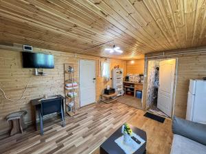ein Wohnzimmer mit Holzdecke und Fernseher in der Unterkunft Cabana IBU in Bumbueşti