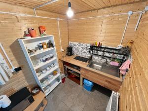 eine kleine Küche mit Spüle und Kühlschrank in der Unterkunft Cabana IBU in Bumbueşti + 15 Fotos