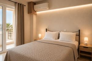 a bedroom with a bed with two lamps and a window at VERADO by A&D Properties in Porto Rafti
