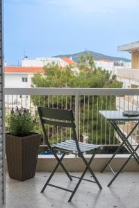 a chair and a table on a balcony at VERADO by A&D Properties in Porto Rafti