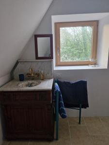 a bathroom with a sink and a window at La Chaumière in Fréhel