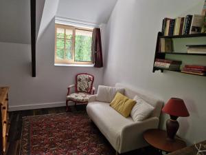 a living room with a couch and a chair at La Chaumière in Fréhel
