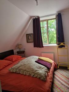 a bedroom with a bed and a window at La Chaumière in Fréhel
