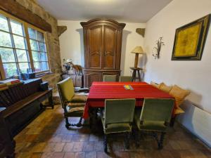 a dining room with a red table and chairs at La Chaumière in Fréhel
