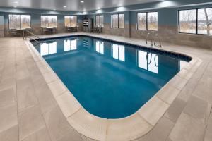 a large pool with blue water in a building at Holiday Inn Express Syracuse-Fairgrounds by IHG in Warners