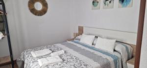 a bedroom with a bed with two towels on it at Vivienda Turistica IBAMA2 in Ciudad-Rodrigo
