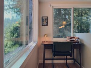 a desk with a chair in front of a window at Evergreen Escape in Felton