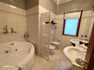 a bathroom with a tub and a toilet and a sink at Casa In Fiore in Mese +12 photos