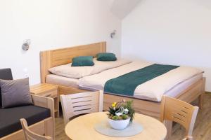a bedroom with a bed and a table with a chair at Penzion Rališka in Horní Bečva