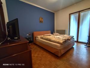 a bedroom with a bed and a flat screen tv at Casa In Fiore in Mese