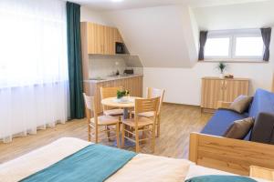 a room with a bed and a table with chairs at Penzion Rališka in Horní Bečva