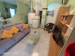 a living room with a purple couch and a mirror at Casa In Fiore in Mese