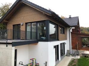 a house with sliding glass doors and a balcony at 5lakes & nature in Starnberg