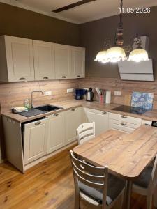 a kitchen with a wooden table and a sink at Ferienwohnung "Altes Schloss Wilhelmsfeld" in Eselsberg