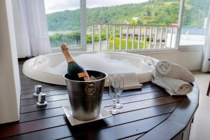 a bottle of champagne in a bucket next to a bath tub at Reserva Praia Hotel in Balneário Camboriú