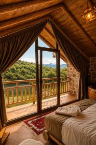 a bedroom with a bed and a large window at Villa Lugina e Kuajve Bulqize in Bulqizë