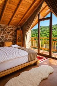 a bedroom with a bed and a large window at Villa Lugina e Kuajve Bulqize in Bulqizë