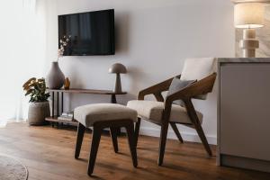 a living room with two chairs and a tv at Nowy Sącz Apartamenty in Nowy Sącz