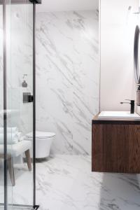 a white bathroom with a toilet and a sink at Nowy Sącz Apartamenty in Nowy Sącz +10 photos