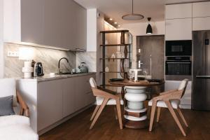 a kitchen with a table and chairs in a room at Nowy Sącz Apartamenty in Nowy Sącz