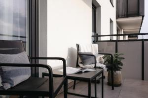 a balcony with two chairs and a table at Nowy Sącz Apartamenty in Nowy Sącz
